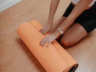 Roll of green yoga mat on white floor